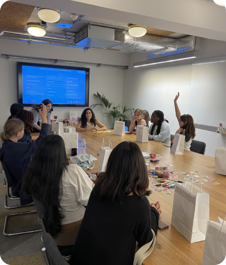the luna team gathered around a table with school children
