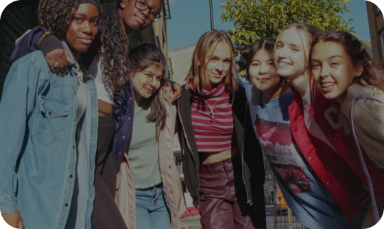 a group of girls standing together with their arms around eachother, smiling